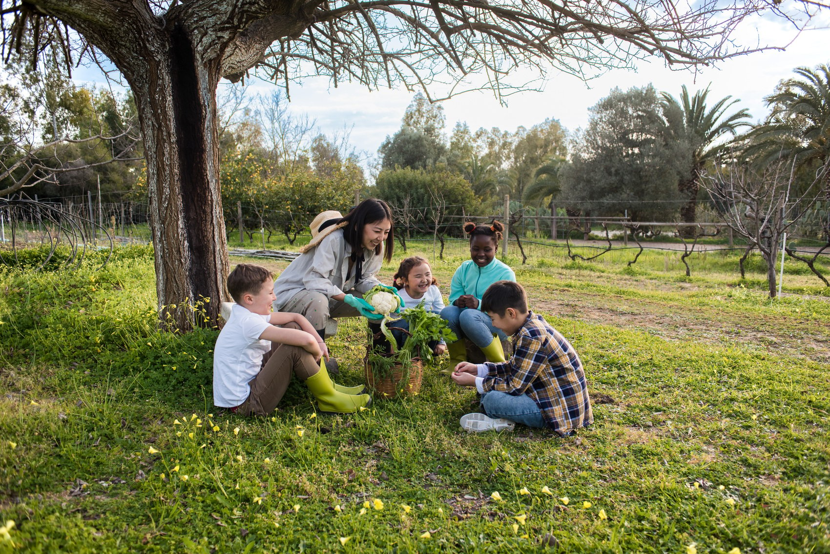 Female Gardener Teaching Kids How to Plant Outdoors